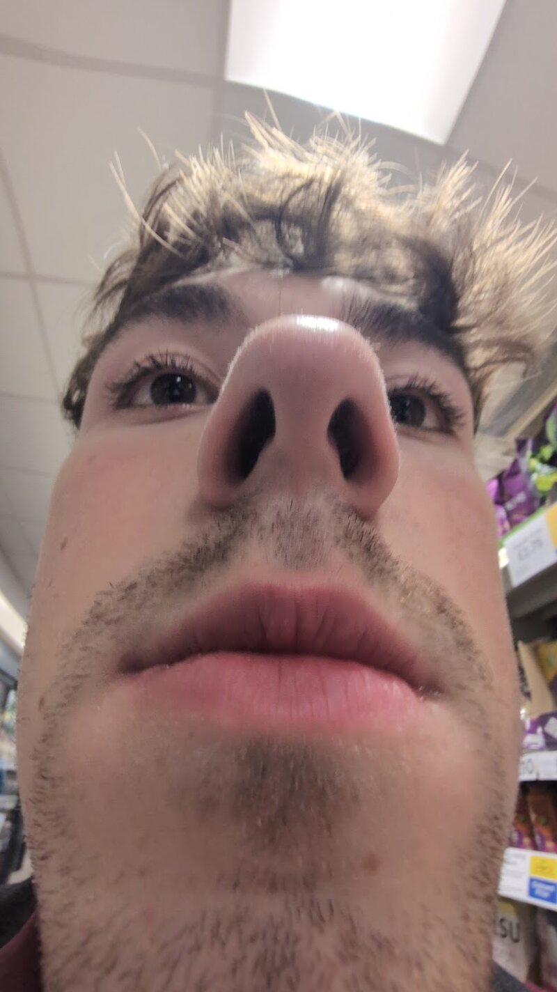 Extreme close-up of Jason's face from below in a supermarket aisle